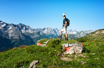 Male hiker pointing upwards in front of mountains