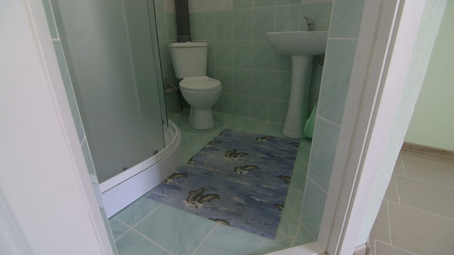 Bathroom with toilet sink and shower in cheap budget hotel room

