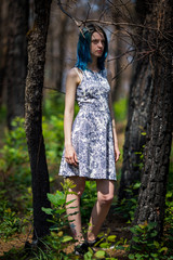 lonely blue-haired pretty girl walk in dreamy forest