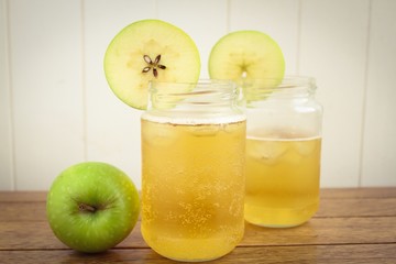 Fototapeta na wymiar Cider apple juice in glass jars on a wooden surface