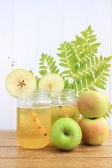 Cider apple juice with apples on a wooden surface