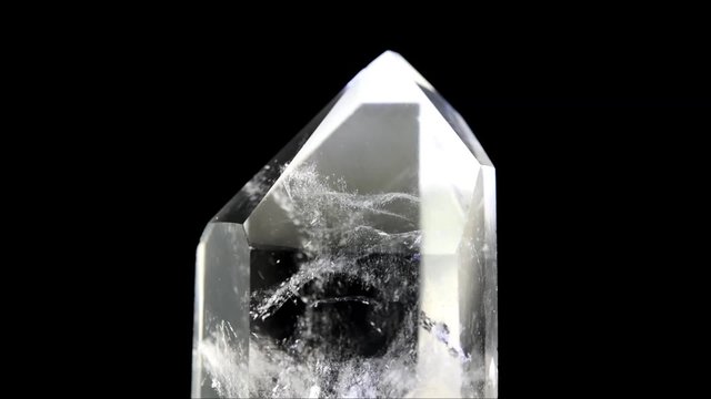 Clear Quartz point rotating on black background