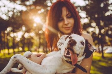 Young woman holding her dog in nature