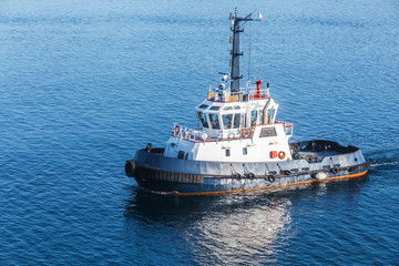 Small tug boat with white superstructure