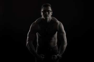 Fototapeta na wymiar Strong athletic man on black background