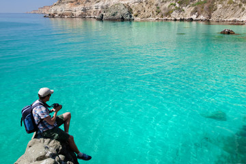 young man photographs the beautiful seascape camera