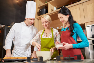 happy women and chef cook baking in kitchen