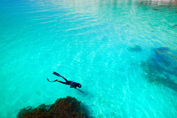 Man diving suit swims in the sea, top view. Activities on the water