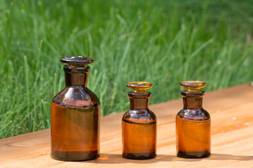 little brown bottles on booden board and grass