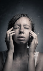 Portrait of a girl, which poured water on gray background.