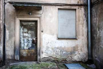 Boarded up window and rusty door