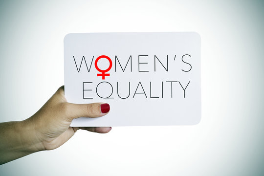 woman holds a signboard with the text womens equality