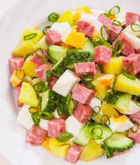 Fresh salad with potato, egg, salami, cucumber and green onion