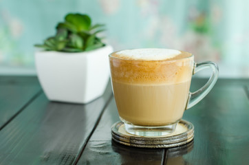 Hot coffee (cappuccino) on wooden table in the coffee shop