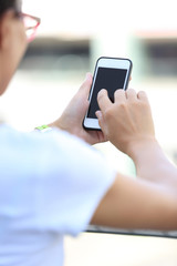 closeup of young woman hands use smart phone in city