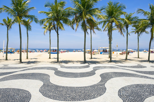 Iconic curving sidewalk tile pattern with palm trees at Copacabana Beach Rio de Janeiro Brazil 