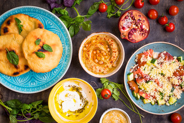 Table served with middle eastern vegetarian dishes. Hummus, tahi
