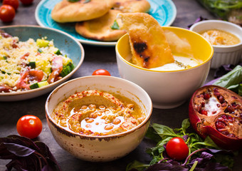 Table served with middle eastern vegetarian dishes. Hummus, tahi