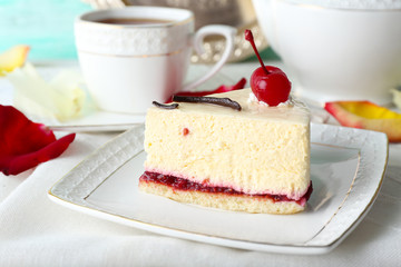 Tasty piece of cheesecake on plate on table close up