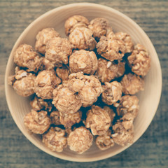 Almond and caramal popcorn on wood background