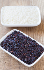 Brown rice and white rice on table wood background
