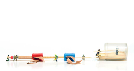 miniature people making tooth stick from pencil