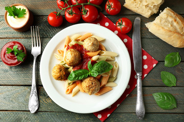 Pasta with meatballs on plate, on wooden  table background