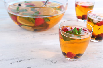 Fruity punch in glassware on wooden table, closeup