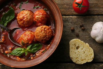Meat balls with tomato sauce, on wooden background