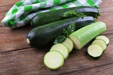 Fresh zucchini with squash and basil on wooden table close up
