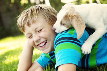 Child lovingly embraces his pet dog
