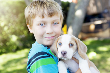 Child lovingly embraces his pet dog