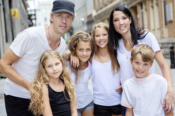 Summer family portrait of parents and kids outside in urban style