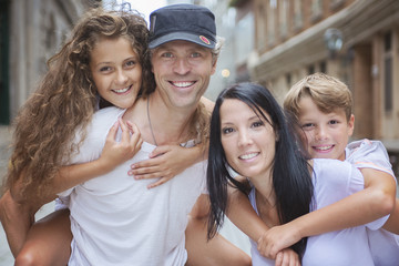 Summer family portrait of parents and kids outside in urban style