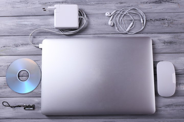 Workplace with laptop and other computer accessories on wooden background