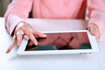 Woman using digital tablet on table close up