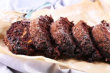Delicious chocolate roll on parchment, closeup