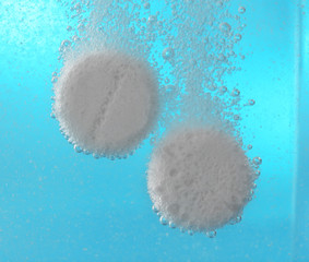 Effervescent painkiller tablets in water, closeup