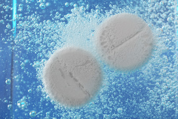 Effervescent painkiller tablets in water, closeup