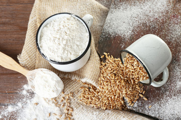 Whole flour with wheat on wooden table, closeup