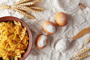 Preparing pasta with white flour and wheat on table, closeup