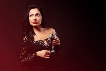 Pretty young woman with wineglass on black background