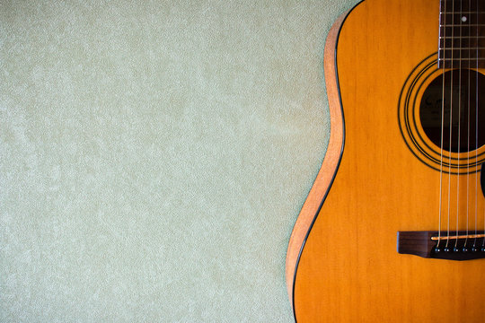 half of an acoustic guitar on a blank background