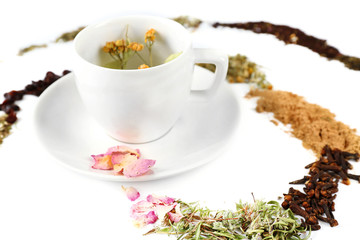 Cup of herbal tea with various kinds of dried herbs isolated on white