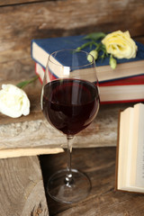 Beautiful composition with glass of wine with old books on table close up