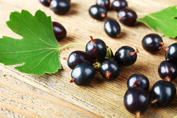 Ripe black currants on wooden background