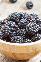 Fresh blackberries in a wooden bowl, selective focus