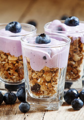 Homemade baked granola with yogurt and blueberries in a glass an