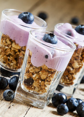 Homemade baked granola with yogurt and blueberries in a glass an