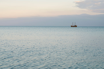 Calm sea and a wooden boat on the horizon